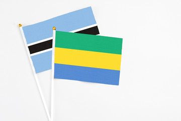 Gabon and Botswana stick flags on white background. High quality fabric, miniature national flag. Peaceful global concept.White floor for copy space.