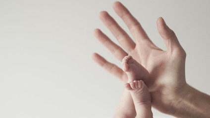Pie de bebé recién nacido en la mano de papá.