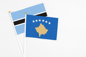 Kosovo and Botswana stick flags on white background. High quality fabric, miniature national flag. Peaceful global concept.White floor for copy space.