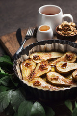 Baked pears on a baking sheet, ready meal. The process of cooking baked fruits with cinnamon, nuts and honey. Shallow depth of field.