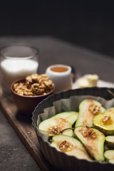 Pears are prepared for baking in the oven. The process of cooking baked fruits with cinnamon, nuts and honey