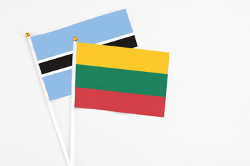 Lithuania and Botswana stick flags on white background. High quality fabric, miniature national flag. Peaceful global concept.White floor for copy space.