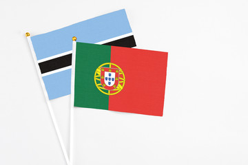 Portugal and Botswana stick flags on white background. High quality fabric, miniature national flag. Peaceful global concept.White floor for copy space.