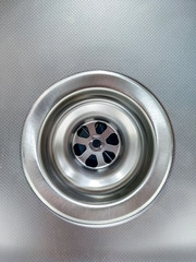 Shiny, clean and new faucet sink hole made of stainless steel metal for water flowing in the bath or sink