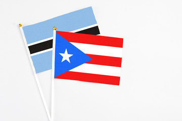 Puerto Rico and Botswana stick flags on white background. High quality fabric, miniature national flag. Peaceful global concept.White floor for copy space.