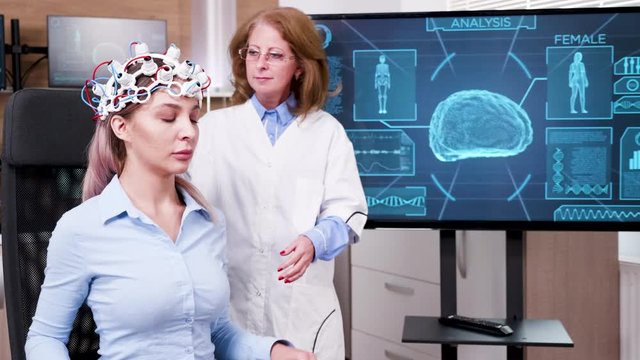 Female scientist checking the brain activity of her patient