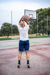 Young basketball player shooting a triple