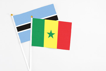 Senegal and Botswana stick flags on white background. High quality fabric, miniature national flag. Peaceful global concept.White floor for copy space.