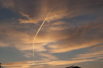 Himmel mit Wolken in der Abenddämmerung und Flugzeugstreifen