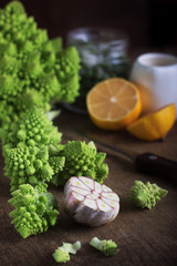 The process of preparing a dish of cauliflower, eggs, cream. Vegetables lie on a wooden cutting board. Shallow depth of field.