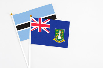 British Virgin Islands and Botswana stick flags on white background. High quality fabric, miniature national flag. Peaceful global concept.White floor for copy space.