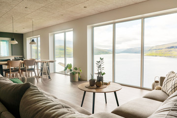 Faroese living room with big window and view on fjord. Scandinavian modern interior.