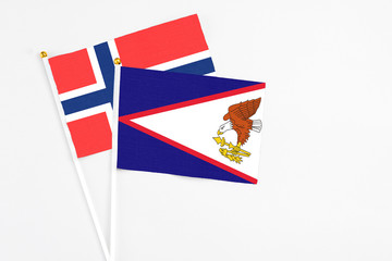 American Samoa and Bouvet Islands stick flags on white background. High quality fabric, miniature national flag. Peaceful global concept.White floor for copy space.