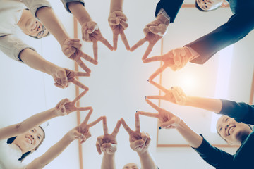 Group of businessmen join hands after completing their targeted tasks.