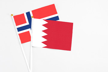 Bahrain and Bouvet Islands stick flags on white background. High quality fabric, miniature national flag. Peaceful global concept.White floor for copy space.