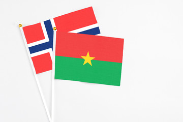 Burkina Faso and Bouvet Islands stick flags on white background. High quality fabric, miniature national flag. Peaceful global concept.White floor for copy space.