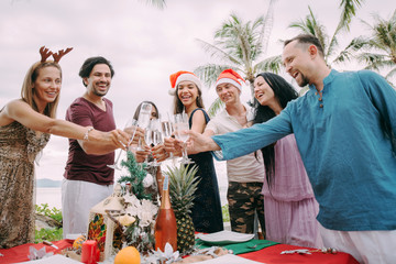 A large company at the New Year's table by the ocean in the tropics.