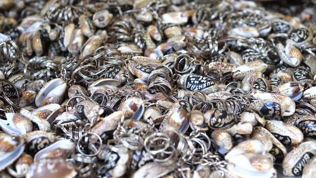 Pan close up shot of seashell keychains - 4K