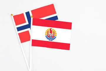 French Polynesia and Bouvet Islands stick flags on white background. High quality fabric, miniature national flag. Peaceful global concept.White floor for copy space.