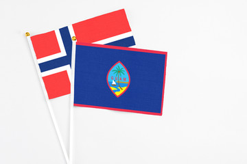 Guam and Bouvet Islands stick flags on white background. High quality fabric, miniature national flag. Peaceful global concept.White floor for copy space.