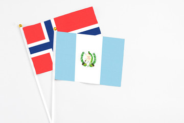 Guatemala and Bouvet Islands stick flags on white background. High quality fabric, miniature national flag. Peaceful global concept.White floor for copy space.