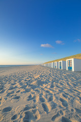 Sunny Beach View With Beach Cabins And High Dunes With Grass At Texel Netherlands