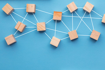 Wooden blocks connected together on a blue background. Teamwork concept