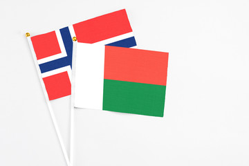 Madagascar and Bouvet Islands stick flags on white background. High quality fabric, miniature national flag. Peaceful global concept.White floor for copy space.