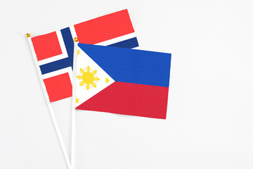 Philippines and Bouvet Islands stick flags on white background. High quality fabric, miniature national flag. Peaceful global concept.White floor for copy space.