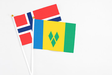 Saint Vincent And The Grenadines and Bouvet Islands stick flags on white background. High quality fabric, miniature national flag. Peaceful global concept.White floor for copy space.