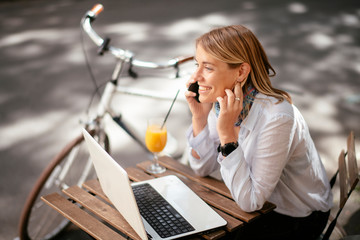 Beautiful businesswoman in cafe. Young woman responding on email while sitting in cafe.