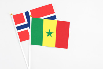 Senegal and Bouvet Islands stick flags on white background. High quality fabric, miniature national flag. Peaceful global concept.White floor for copy space.