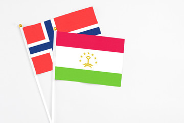 Tajikistan and Bouvet Islands stick flags on white background. High quality fabric, miniature national flag. Peaceful global concept.White floor for copy space.