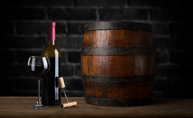 Pouring red wine into the glass against wooden background
