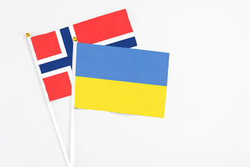 Ukraine and Bouvet Islands stick flags on white background. High quality fabric, miniature national flag. Peaceful global concept.White floor for copy space.