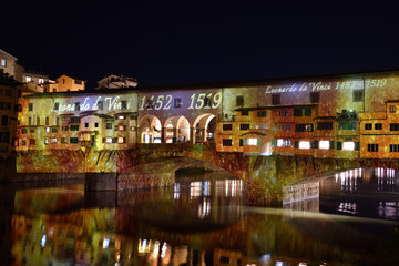 Italy, Florence, December 2018: The famous Ponte Vecchio of Florence illuminated in occasion of F-Light - Festival of Lights with the masterpieces of Leonardo da Vinci during the Christmas season.