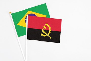 Angola and Brazil stick flags on white background. High quality fabric, miniature national flag. Peaceful global concept.White floor for copy space.