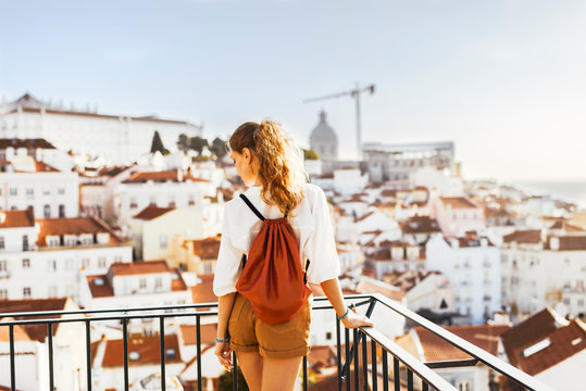Traveller wearing a bag and white shirt exploring beautiful cityscape of Iberic country in Europe during summer sunset