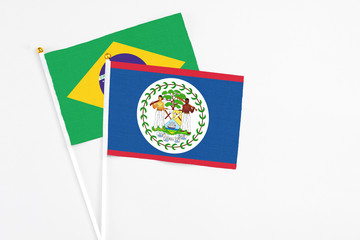 Belize and Brazil stick flags on white background. High quality fabric, miniature national flag. Peaceful global concept.White floor for copy space.