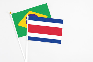 Costa Rica and Brazil stick flags on white background. High quality fabric, miniature national flag. Peaceful global concept.White floor for copy space.