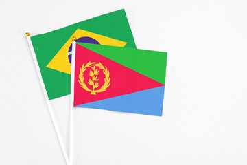 Eritrea and Brazil stick flags on white background. High quality fabric, miniature national flag. Peaceful global concept.White floor for copy space.