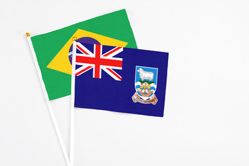 Falkland Islands and Brazil stick flags on white background. High quality fabric, miniature national flag. Peaceful global concept.White floor for copy space.