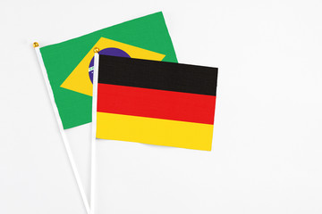 Germany and Brazil stick flags on white background. High quality fabric, miniature national flag. Peaceful global concept.White floor for copy space.
