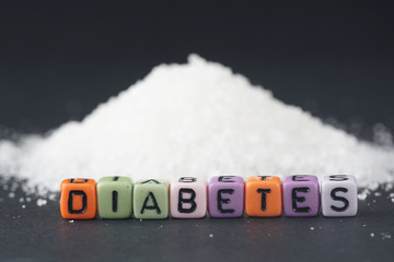 Diabetes words on a sugar coating over black background