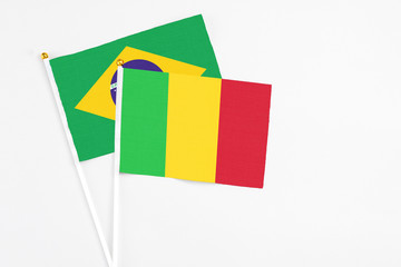 Mali and Brazil stick flags on white background. High quality fabric, miniature national flag. Peaceful global concept.White floor for copy space.