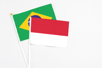Monaco and Brazil stick flags on white background. High quality fabric, miniature national flag. Peaceful global concept.White floor for copy space.