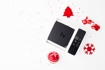Set of controller and micro console for TV watching and online streaming. Red Christmas toys on the...