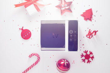 Set of controller and micro console for TV watching and online streaming. Red Christmas toys on the...