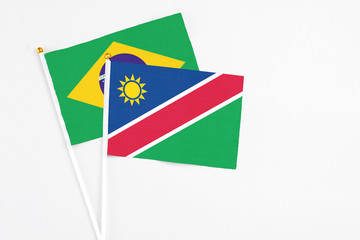 Namibia and Brazil stick flags on white background. High quality fabric, miniature national flag. Peaceful global concept.White floor for copy space.
