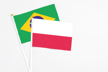 Poland and Brazil stick flags on white background. High quality fabric, miniature national flag. Peaceful global concept.White floor for copy space.